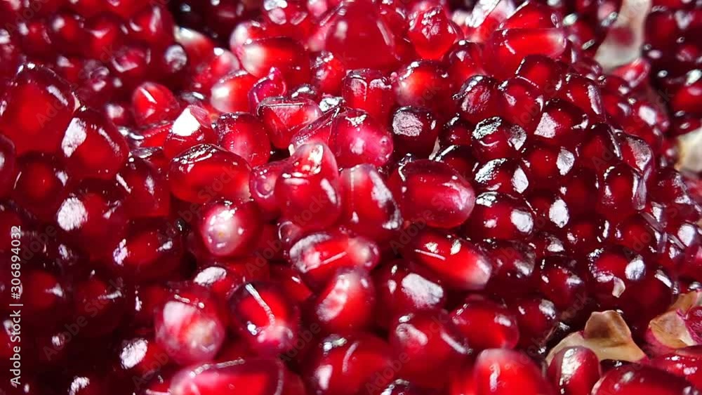 Shining juicy grains of red pomegranate are falling and bouncing Shining juicy grains of red pomegranate are falling and bouncing