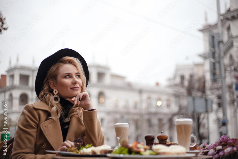 Beautiful european woman sit in the terrace of cafe in france style and the female have a breakfast in . the hands holding the fork with knife to eat salad, peached egg m toasted, bacon and latte Beautiful european woman sit in the terrace of cafe in france style and the female have a breakfast in . the hands holding the fork with knife to eat salad, peached egg m toasted, bacon and latte