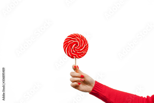 Red and white spiral lollipop in women hand isolated on white background