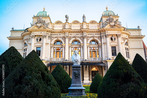 Front view of monumental, rich decored with sculptures and ornaments building of Juliusz Slowacki Theatre in Cracow (Krakow) old town in Poland at dusk