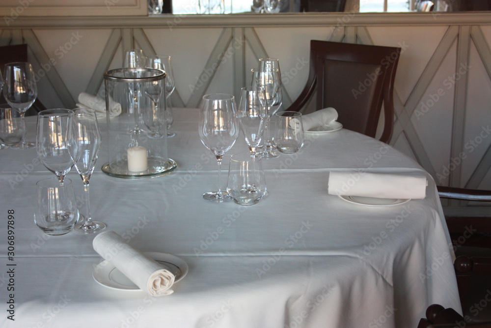 dining table set up and set up with a lot of elegance in the dining room of a restaurant or the dining room of a very rich house, in light white colors dining table set up and set up with a lot of elegance in the dining room of a restaurant or the dining room of a very rich house, in light white colors