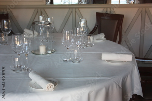 dining table set up and set up with a lot of elegance in the dining room of a restaurant or the dining room of a very rich house  in light white colors