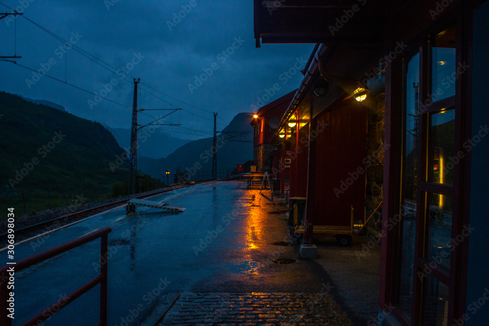 Cloudy evening on the street of empty train station. Completely alone. Rails and mountains are visible. Cloudy evening on the street of empty train station. Completely alone. Rails and mountains are visible.