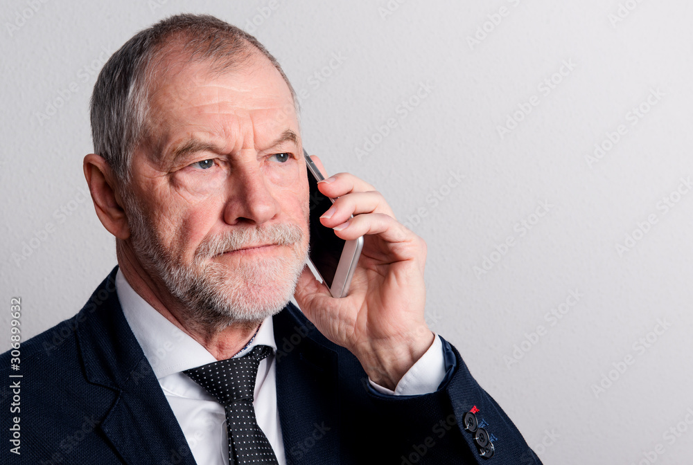 Portrait of a senior man with smartphone in a studio, making phone call. Portrait of a senior man with smartphone in a studio, making phone call.
