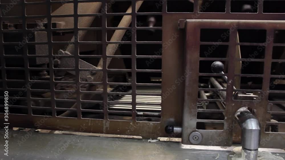 On a conveyor belt, the press makes cakes for chocolate wafers. The conveyor is located behind the fence. Close-up video On a conveyor belt, the press makes cakes for chocolate wafers. The conveyor is located behind the fence. Close-up video