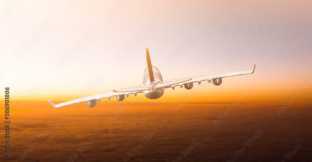 Huge two-storey passengers commercial airplane flying above clouds in sunset light. Concept of fast travel, holidays and business