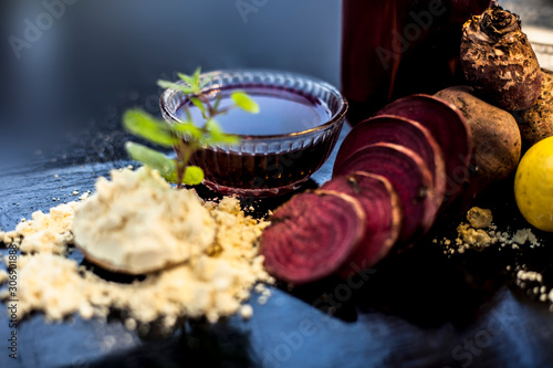 Face mask for a natural glow for all skin types on the black wooden surface consisting of some beetroot juice, yogurt, lime juice, and gram flour. Shot of face mask with entire ingredients.Horizontal  photo