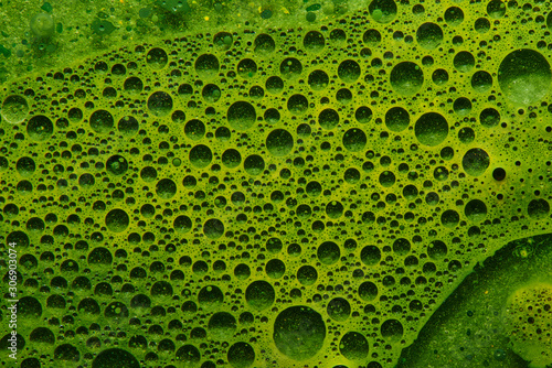 Abstract liquid background fresh green vegetable juice with water bubbles, geometric circles chlorophyll