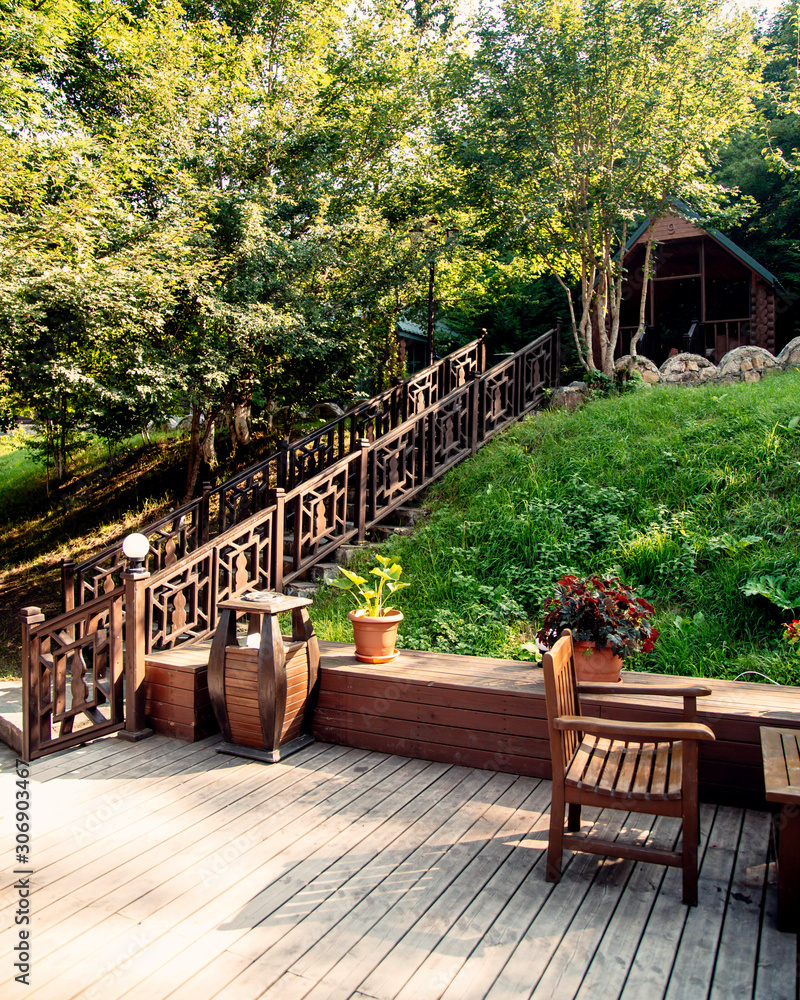 wooden staircase in the green restaurant garden with chairs and table