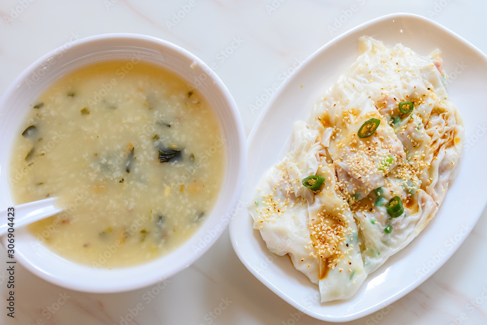 top view traditonal Cantonese food of cheong fun or rice noodle rolls and bowl of porridge top view traditonal Cantonese food of cheong fun or rice noodle rolls and bowl of porridge