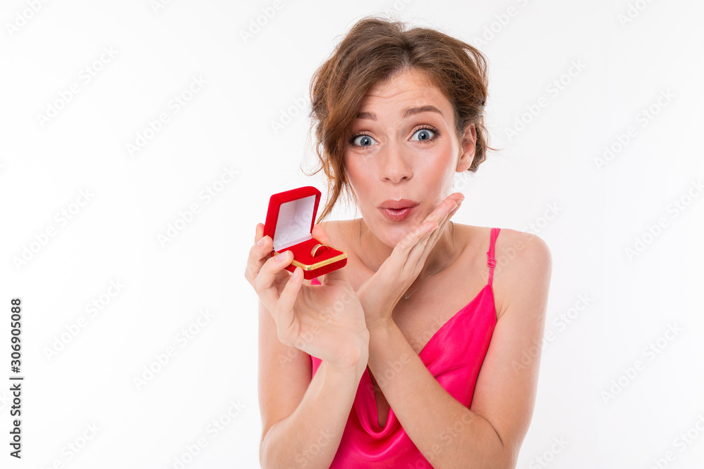 Young beautiful girl holds a box for a engagement ring and rejoices isolated on white background Young beautiful girl holds a box for a engagement ring and rejoices isolated on white background