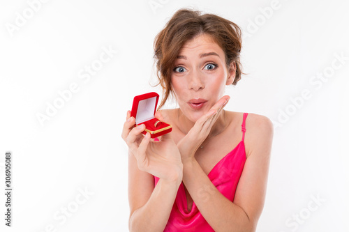 Young beautiful girl holds a box for a engagement ring and rejoices isolated on white background