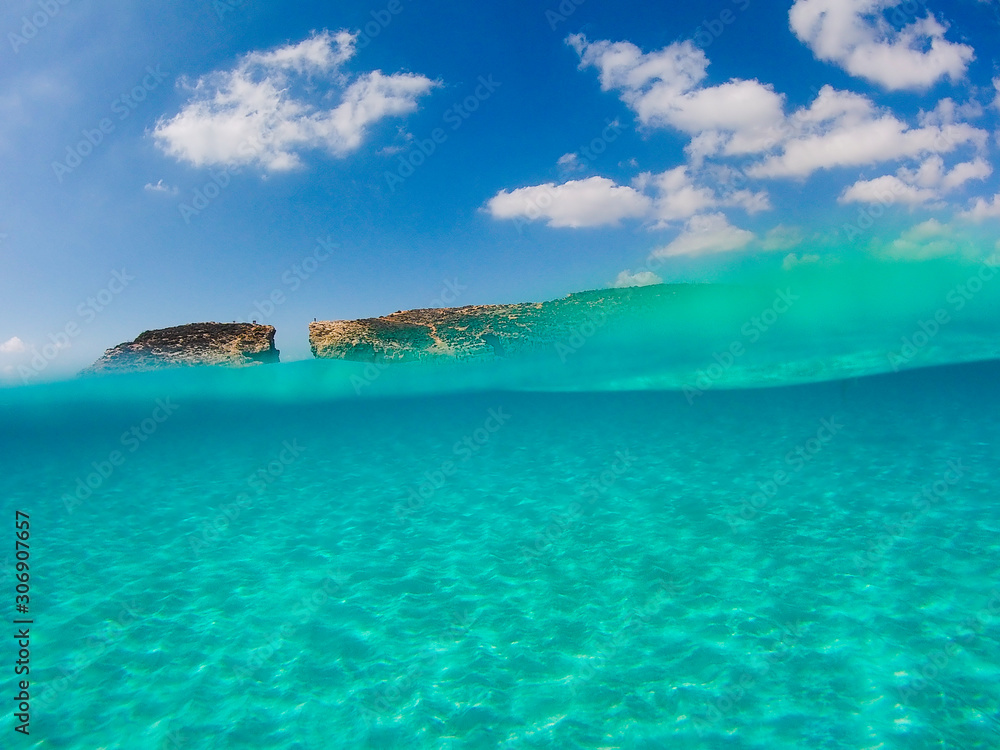 Half underwater photograph in the mediterranean sea with sandy ground