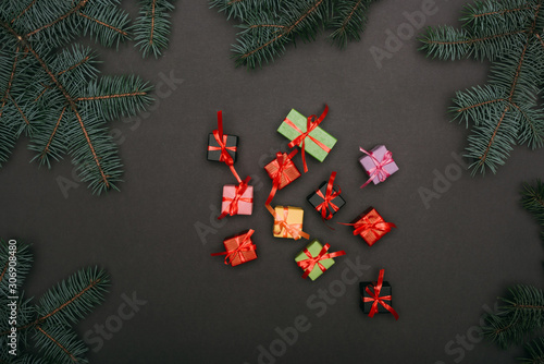 top view of little gift boxes with spruce branches on black