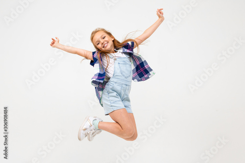 happy european girl jumping on a white wall
