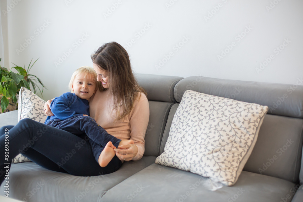 Mother, tickling her little toddler boy, child giggling at home Mother, tickling her little toddler boy, child giggling at home