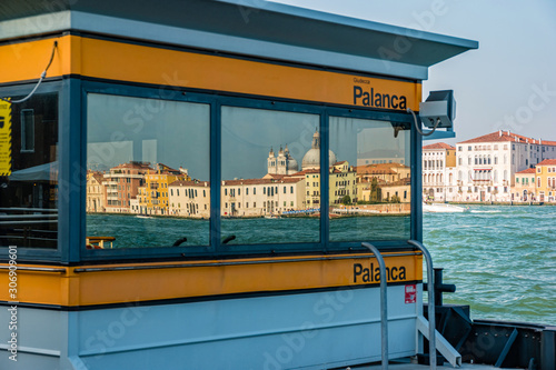 Reflections of venetian buildings in windows of vaporetto station in Venice, Italy