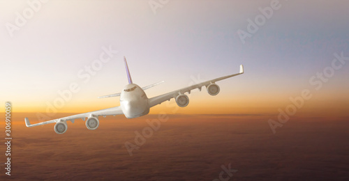 Airplane flying above clouds during sunset