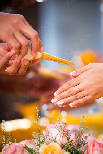 Hands pouring blessing water into bride's bands, Thai wedding.Wedding ceremony in Thailand.