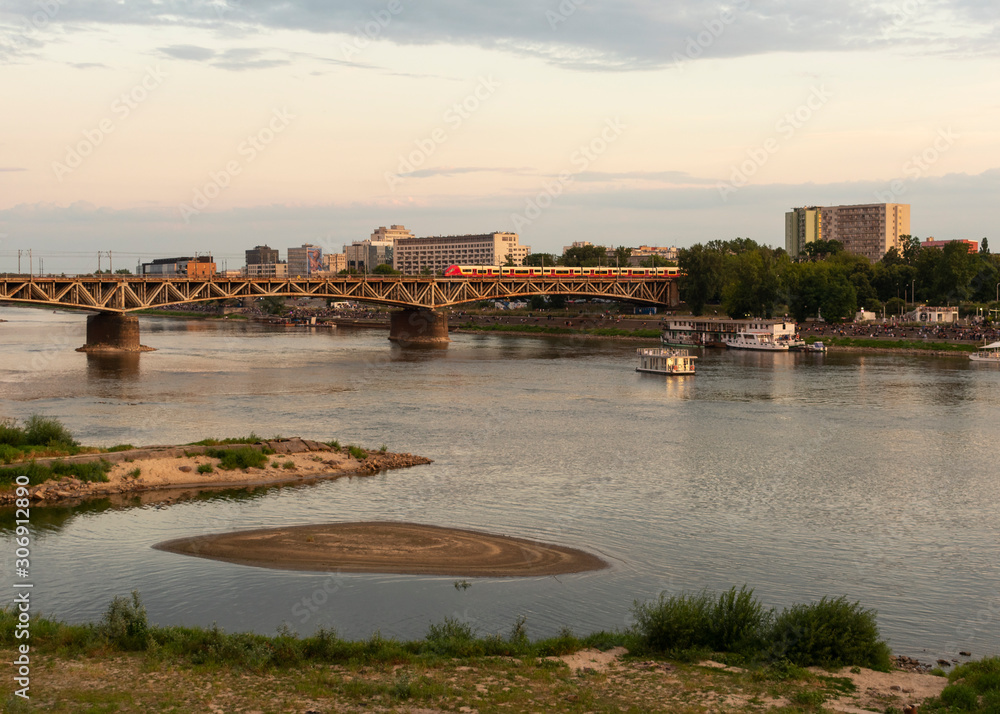 Naklejka premium Warsaw, Poland/Europe; 12/07/2019: Railway bridge over the Vistula river at sunset in Warsaw, Poland