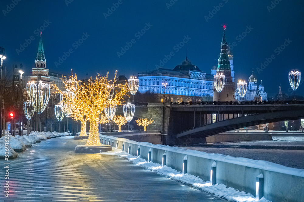 Obraz premium Moscow. Russia. Christmas evening in the capital of the Russian Federation. Moscow is decorated for the New year. Kremlin embankment with glowing garlands. The embankment of the Moscow river is empty