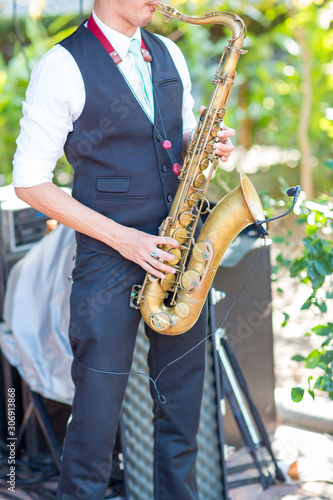 Gorgeous saxophonist lady is playing saxophone in wedding ceremony. musician woman. attractive woman and music instrument . classical and romantic happiness events. image for objects and copy space.