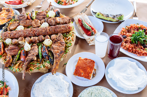 Traditional Turkish Adana kebab or kebap meat food, appetizers, raki and salgam on table from top view in turkish restaurant. 