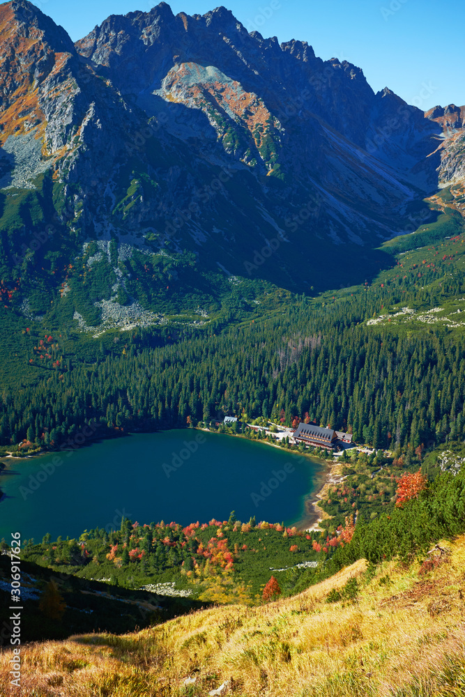 Portrait oriented landscape of the beautiful autumn Poprad lake surrounded by high peaks of Tatra mountains in Slovakia