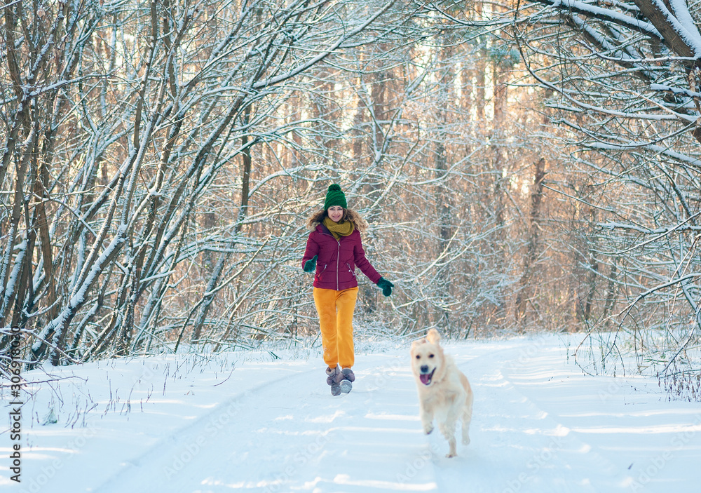Portrait Young woman in winter park walking with her dog golden retriever. Friendship, pet and human. Portrait Young woman in winter park walking with her dog golden retriever. Friendship, pet and human.