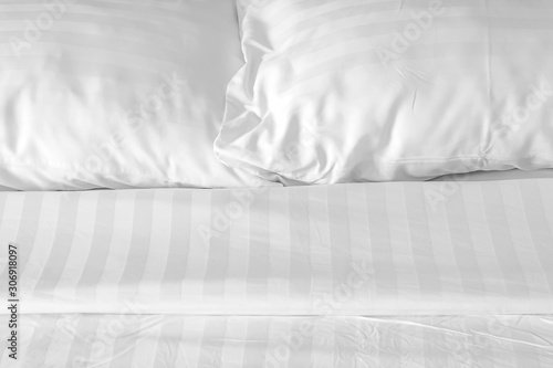 white pillow with messy messy blanket on bed in bedroom Close up of bedding sheets with copy space.