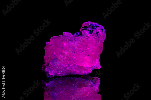 Foto macro mineral stone calcite under ultraviolet light on a black background