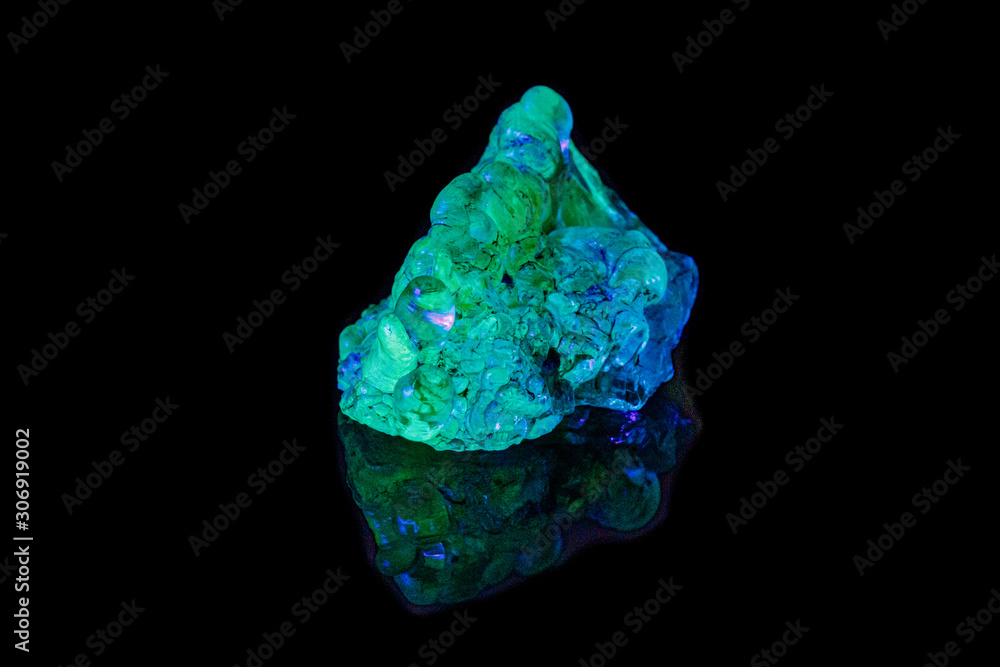 Fototapeta premium macro mineral stone opal under ultraviolet light on a black background