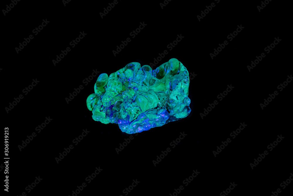 macro mineral stone opal under ultraviolet light on a black background macro mineral stone opal under ultraviolet light on a black background