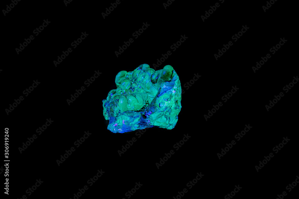 Fototapeta premium macro mineral stone opal under ultraviolet light on a black background