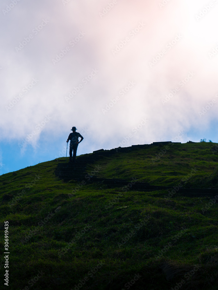 Silhouette of a hiker with hat in mountains