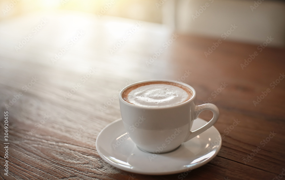 Blurred images of ready-to-drink cappuccino cups placed on a wooden table in the morning as background images and beautiful illustrations Blurred images of ready-to-drink cappuccino cups placed on a wooden table in the morning as background images and beautiful illustrations
