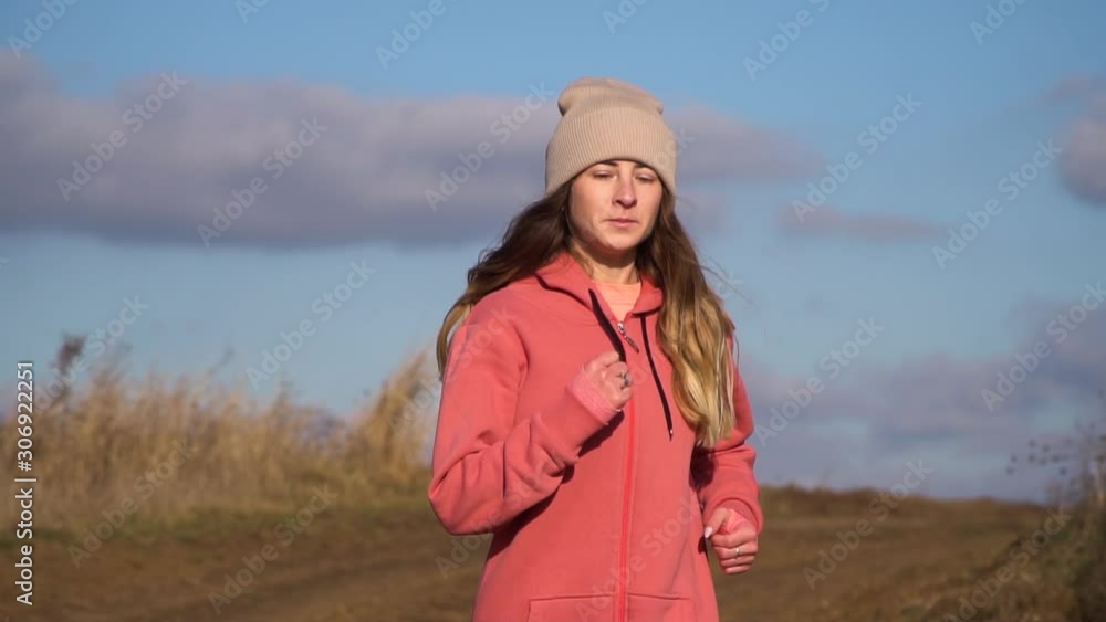 Young beautiful girl running around every morning. Running down from the hill, the girl runs past the camera Young beautiful girl running around every morning. Running down from the hill, the girl runs past the camera