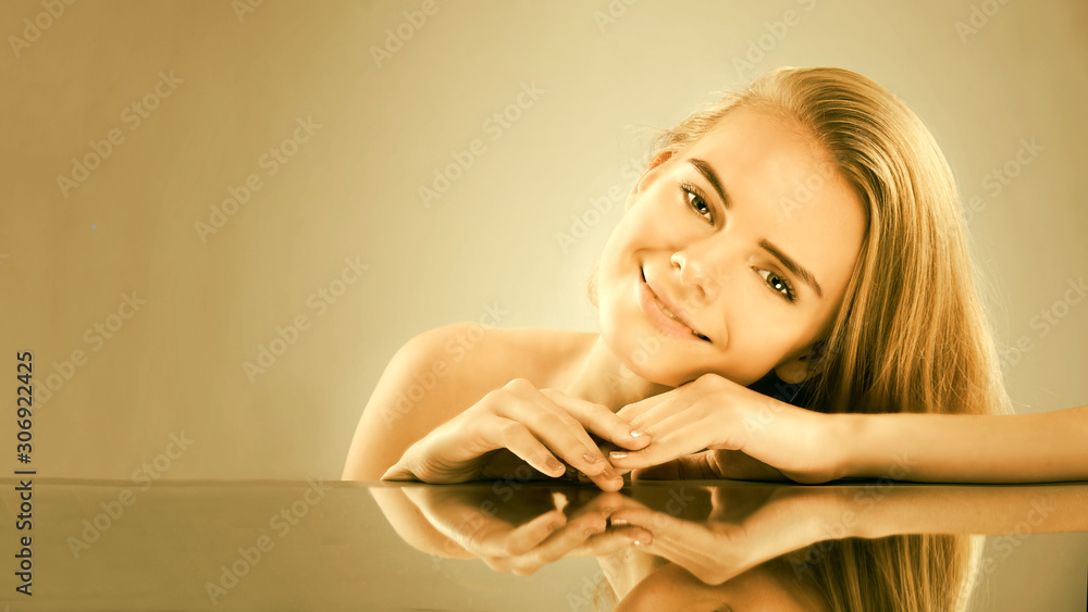 Naklejka premium Young beautiful woman with closed eyes demonstrates well-groomed hands. golden tint