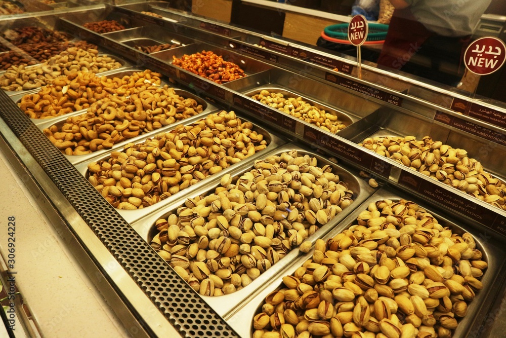 Selection of nuts on display in shop in stainless steel containers