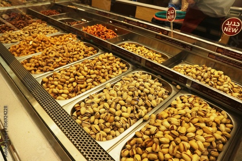 Selection of nuts on display in shop in stainless steel containers