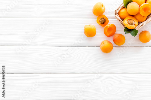 Collect apricots  white wooden background top view copy space  pattern with leaves