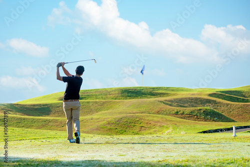 Professional golfer asian man approach on the tee off for swing and hitting golf ball and looking fairway in course. Hobby in holiday and vacations sunny morning club golf. Lifestyle sport Concept.