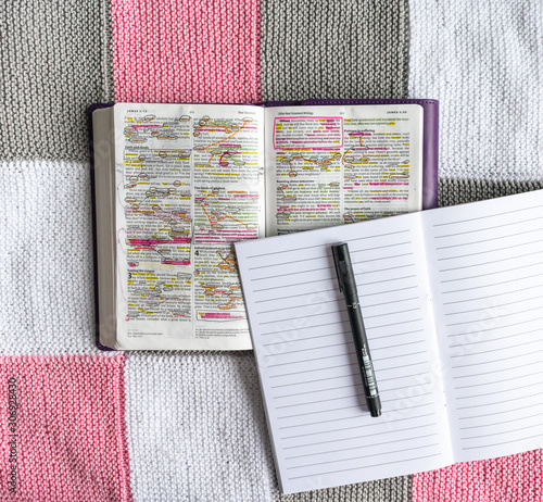 Open Bible flat lay on white, grey and pink background 