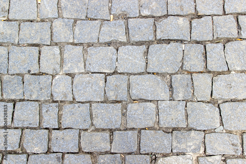 An old stoneblock pavement cobbled with square stone blocks An old stoneblock pavement cobbled with square stone blocks