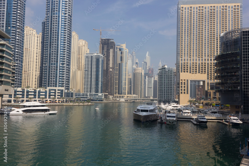 view from the pier of Dubai marina with its boats and skyscrapers