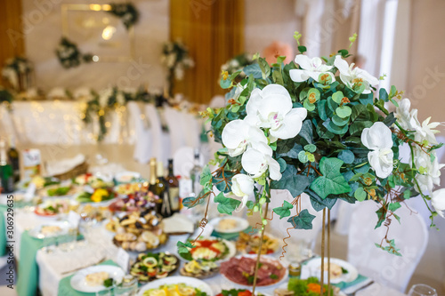 Beautiful flowers on elegant dinner table in wedding day. Decorations served on the festive table in blurred background