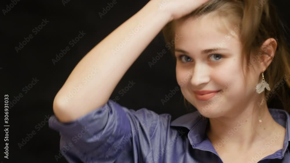 cute beautiful girl on a black background looking at her appearance in mirror, young woman having fun fooling around and making eyes big, concept female beauty cute beautiful girl on a black background looking at her appearance in mirror, young woman having fun fooling around and making eyes big, concept female beauty