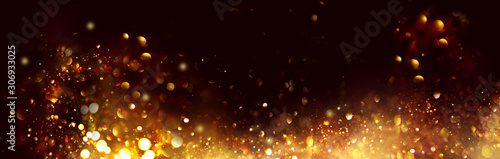 Golden Christmas and New Year glittering stars swirl on black bokeh background, backdrop with sparkling golden stars, holiday garland, magic glowing dust, lights. Gold Abstract Glitter Blinking sparks © Subbotina Anna