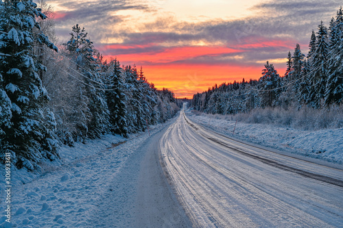 winter road in Varmland Sweden and orange sunrise