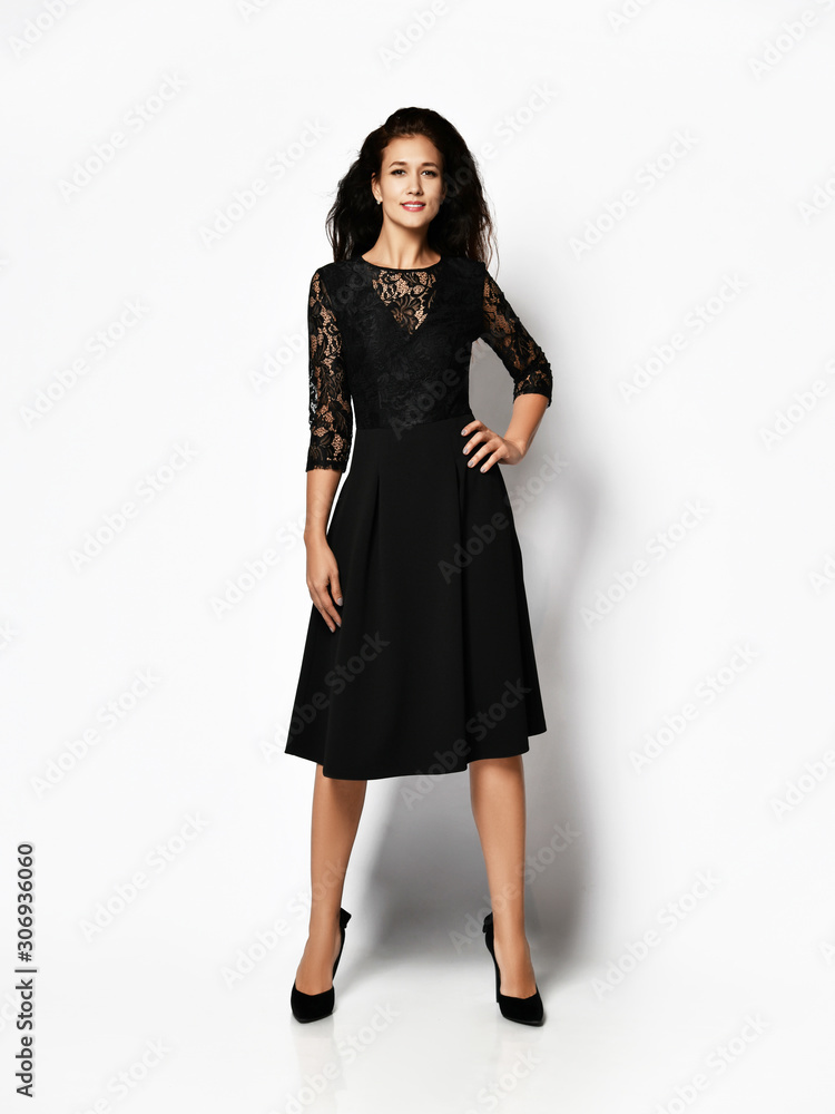 Young beautiful woman posing in new fashion long casual dark black winter dress happy smiling walking full body Young beautiful woman posing in new fashion long casual dark black winter dress happy smiling walking full body